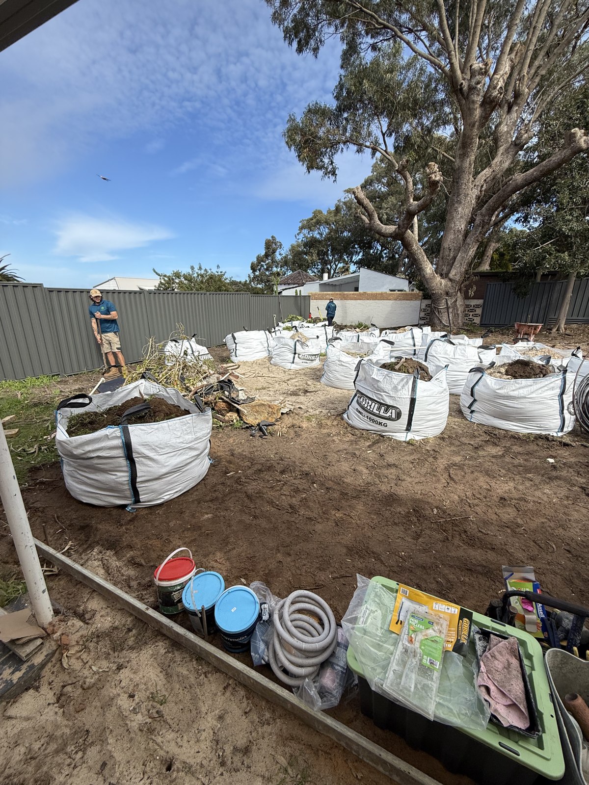 Cleared garden area with bags of materials ready for removal